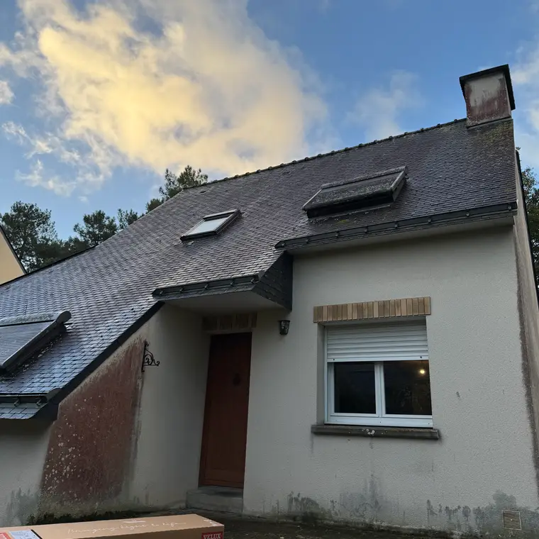 Maison avec une toiture en ardoise et des lucarnes